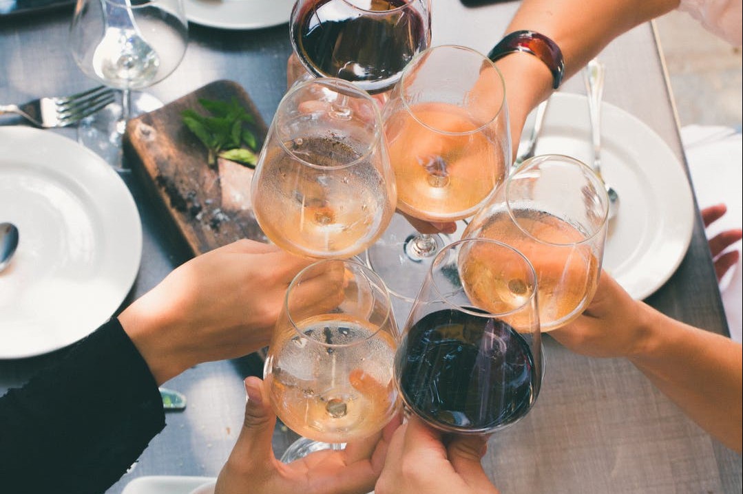 Group of people holding wine glasses together