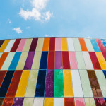 low-angle photography of building with red, green, and white curtain wall